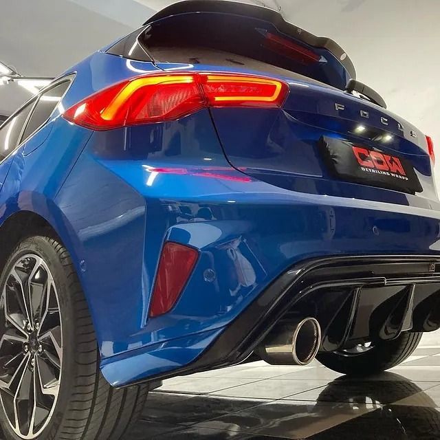 Un coche Ford azul está aparcado en una sala de exposición.
