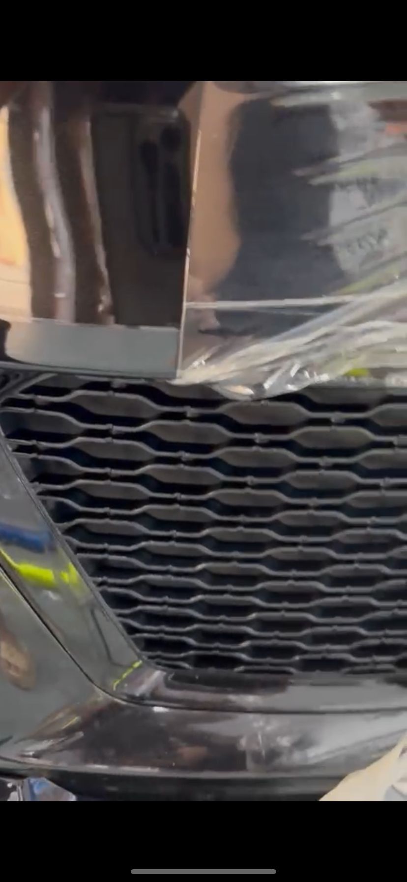 Un primer plano de la parrilla y los faros de un coche.