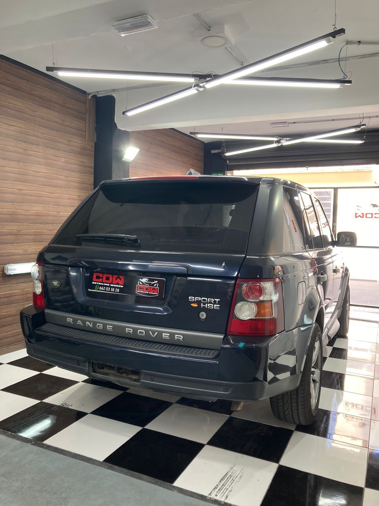 Un Range Rover está estacionado en un garaje con suelo cuadriculado.