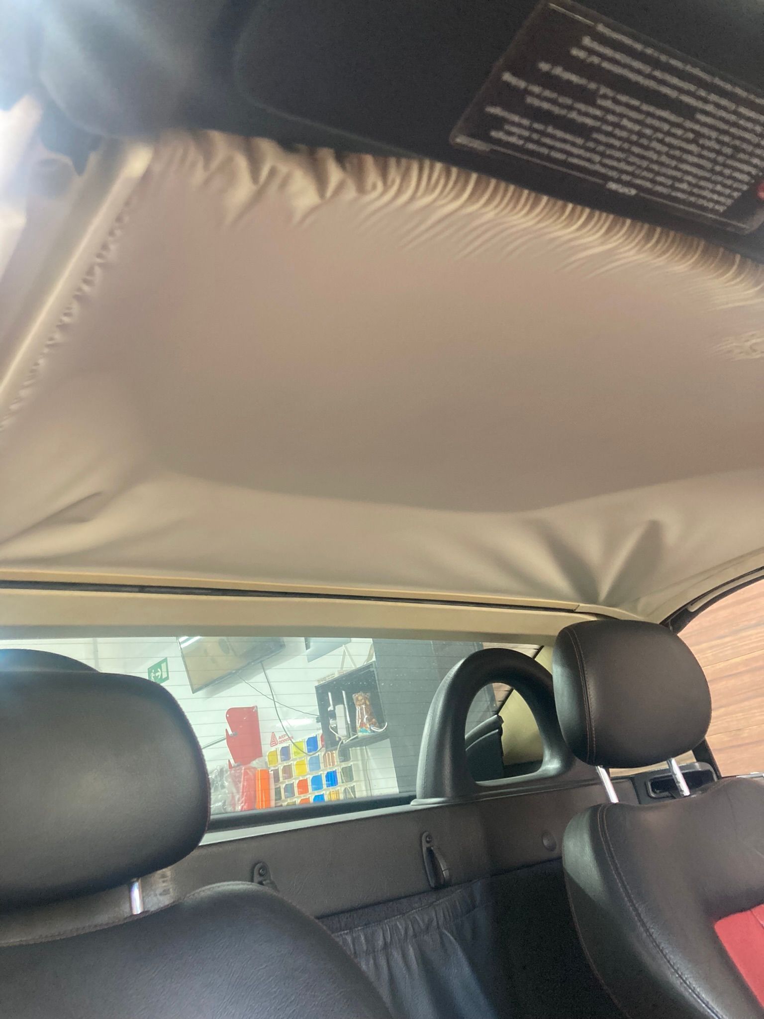 El techo de un coche está abierto y los reposacabezas son negros.