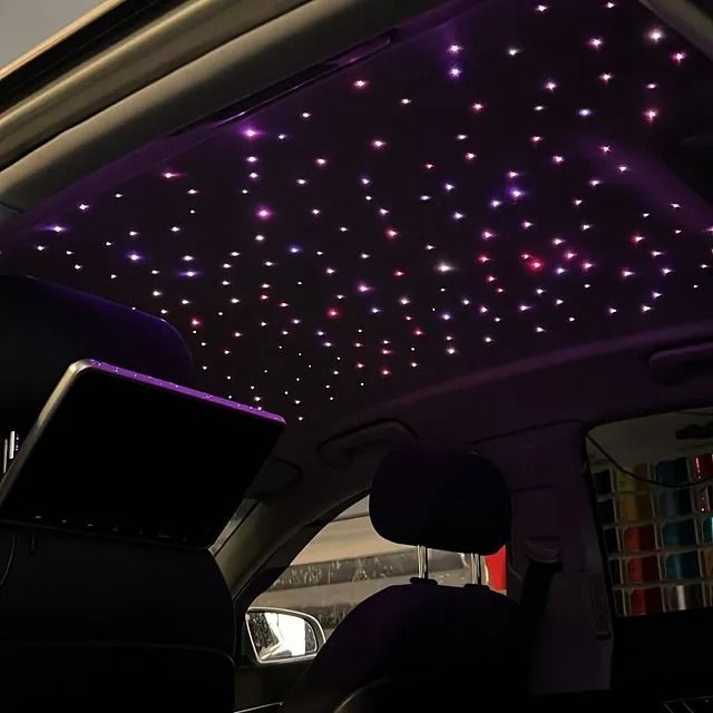El techo de un coche está iluminado con luces moradas.