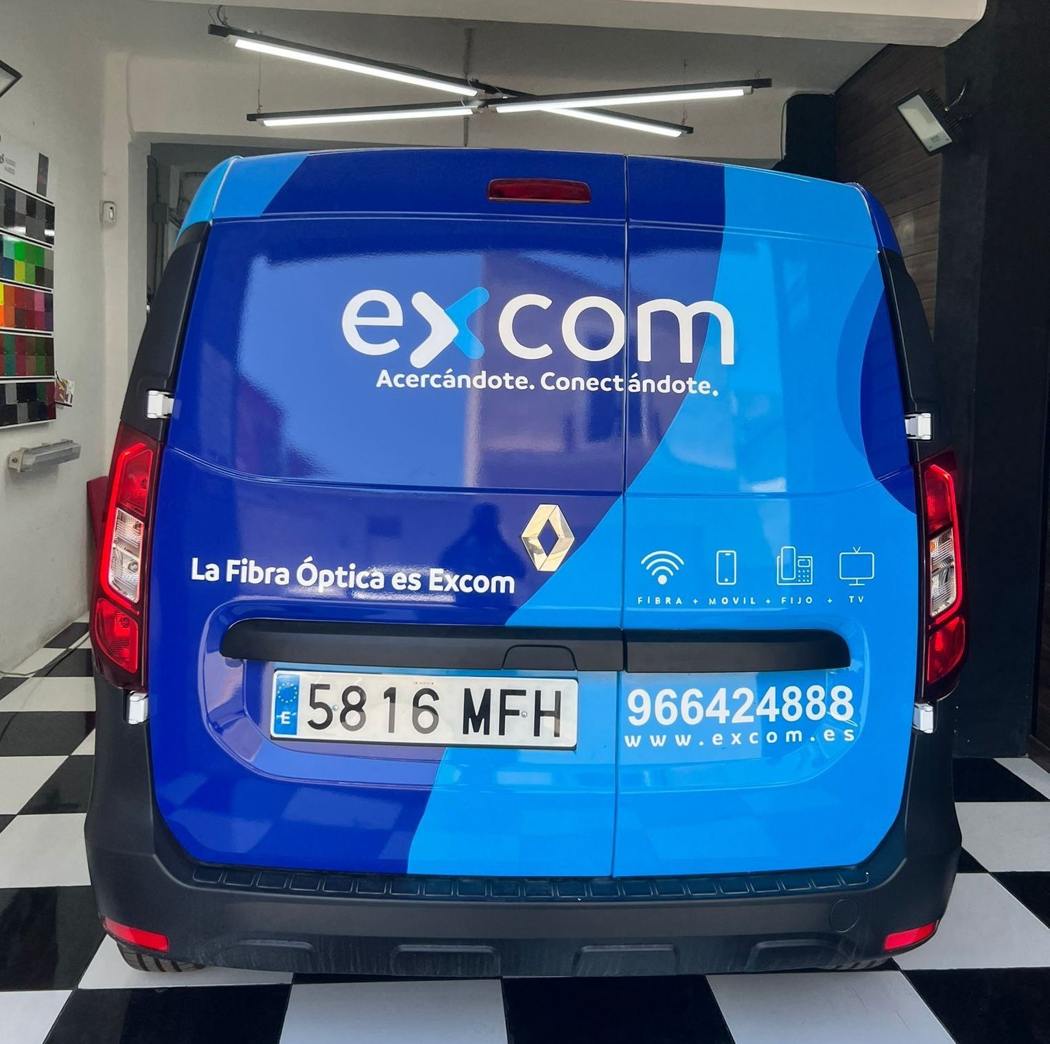 Una camioneta azul con la palabra excom en la parte trasera
