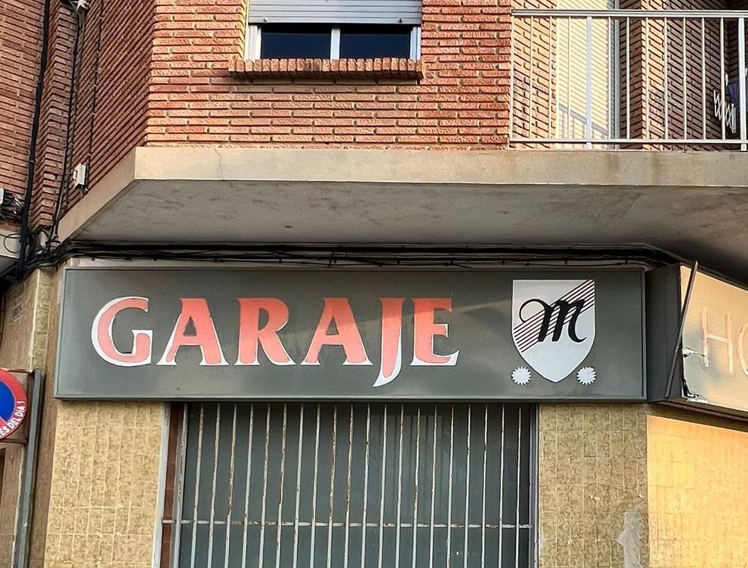 Un cartel en el costado de un edificio que dice garaje.