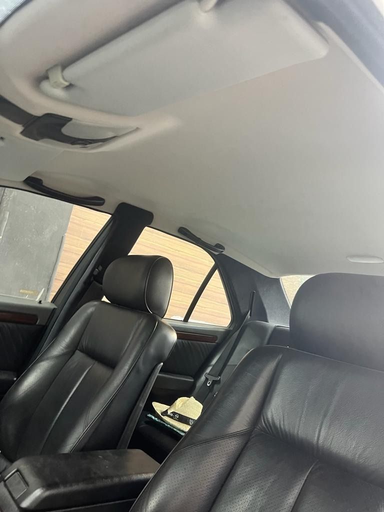 El interior de un coche con asientos de cuero negro y una visera para el sol.