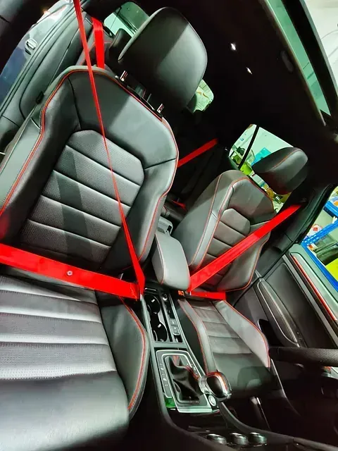 Un coche negro con cinturones de seguridad rojos en los asientos.
