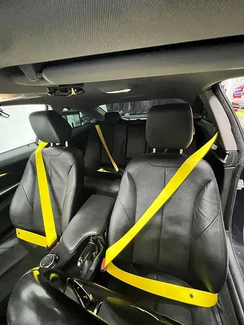Un coche negro con cinturones de seguridad amarillos en los asientos.