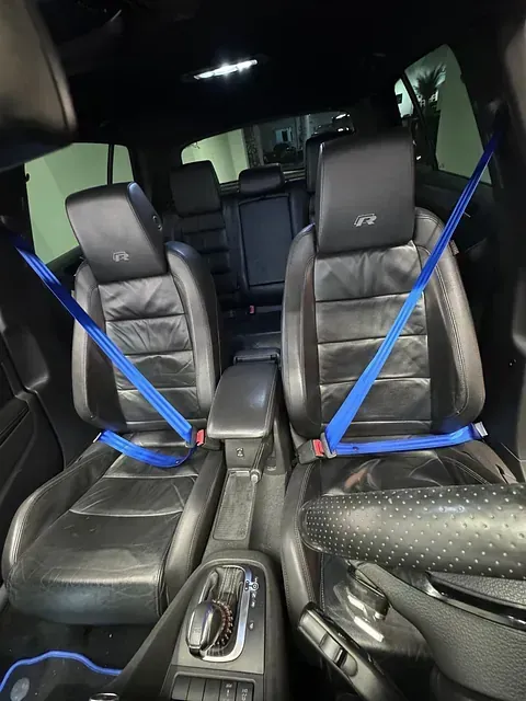 El interior de un coche con cinturones de seguridad azules.