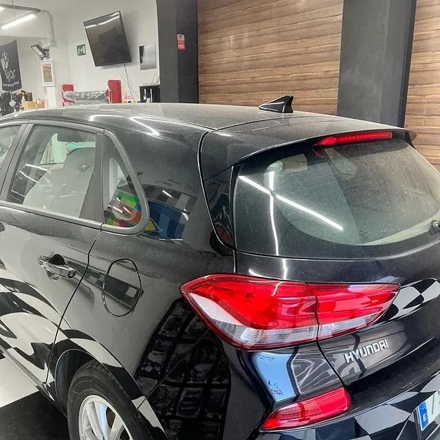 Un Hyundai hatchback negro está estacionado en un garaje.