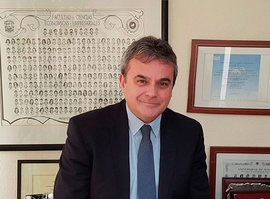 Un hombre con traje y corbata está parado frente a una pared con números.