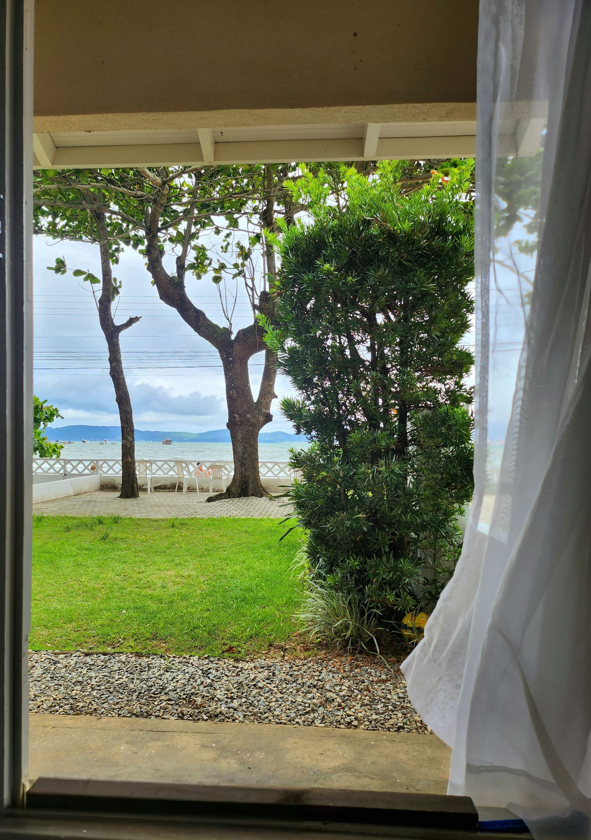 Fenêtre ouverte d'une maison avec vue mer.