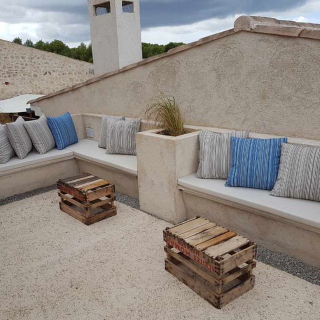 Un patio con un sofá y dos cajas de madera.