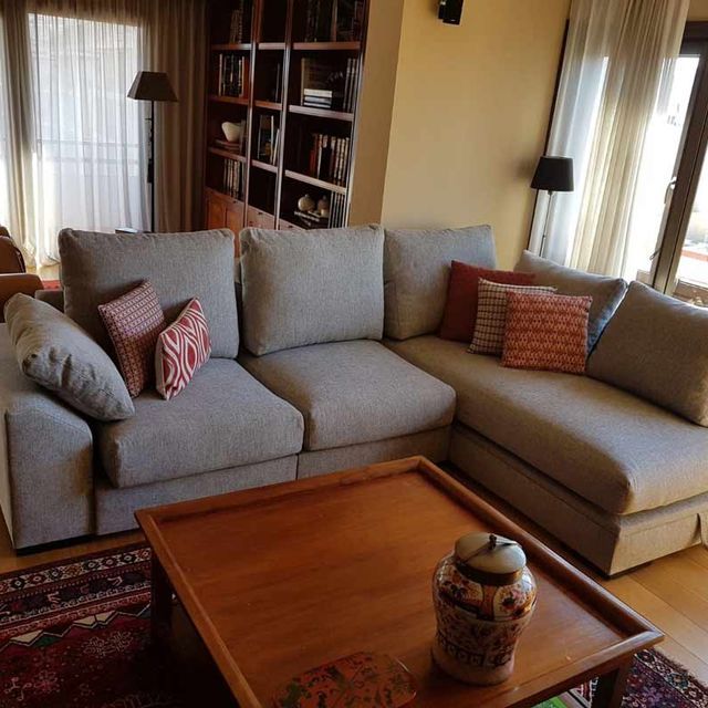 Una sala de estar con un sofá seccional y una mesa de café.