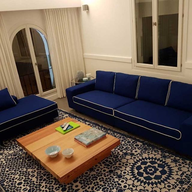 Una sala de estar con dos sofás azules y una mesa de centro de madera.