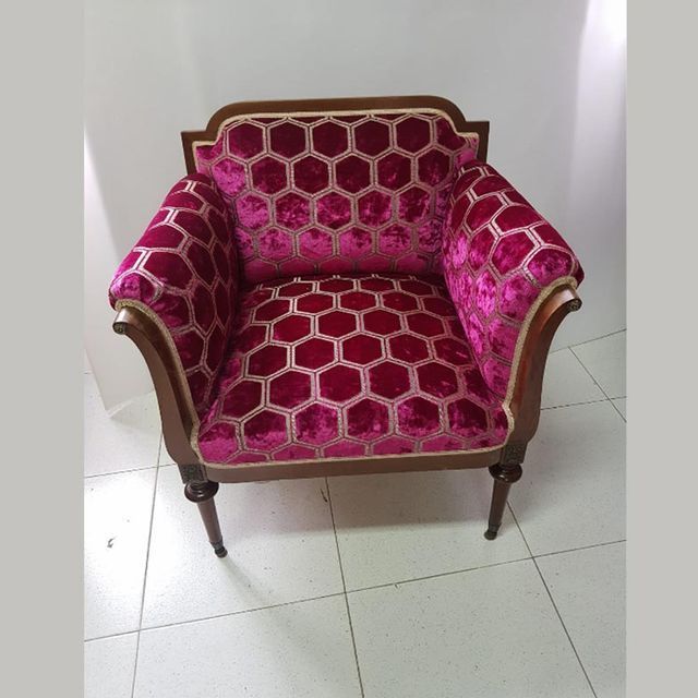 Una silla con un patrón rosa y dorado.