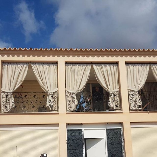 Un edificio con muchas ventanas y cortinas