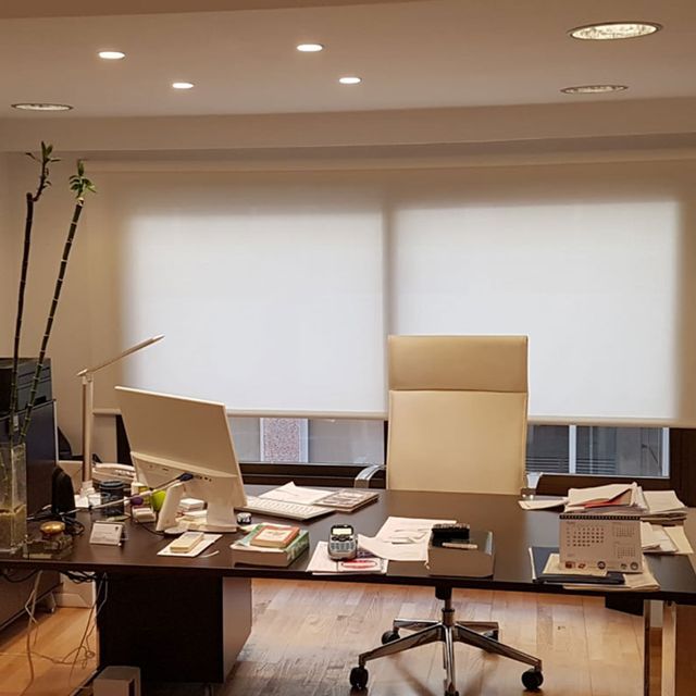 Un escritorio con una computadora y una silla en una oficina.