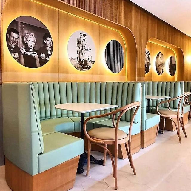 Una fila de cabinas con mesas y sillas en un restaurante.