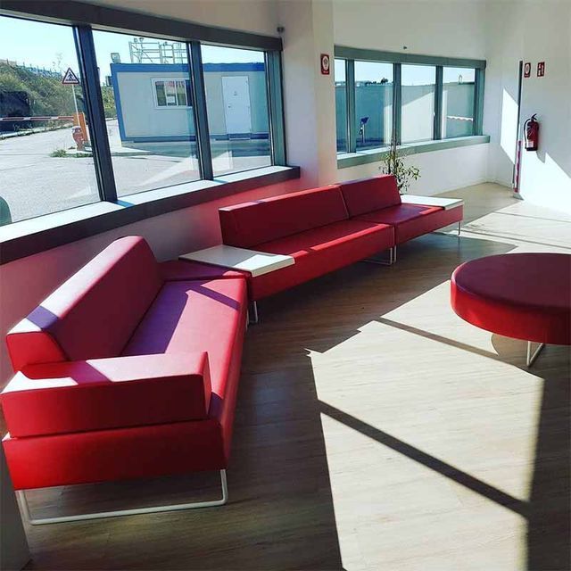 Una sala de estar con un sofá rojo y una mesa redonda.