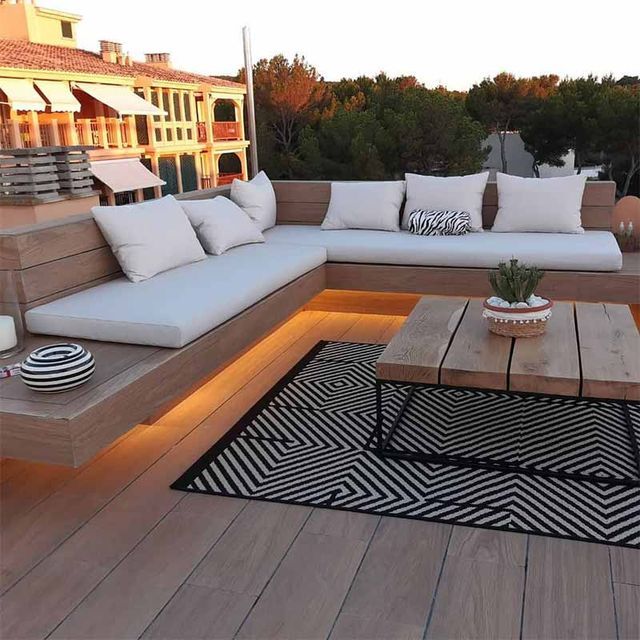 Una terraza de madera con un sofá y una mesa de café.