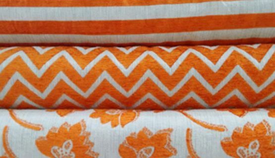 Tres piezas de tela naranja y blanca se apilan una encima de otra.