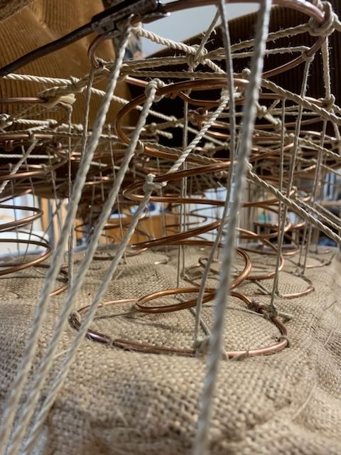 Weiße, horizontale Jalousien sind geschlossen und lassen helles Tageslicht teilweise in einen Innenraum.