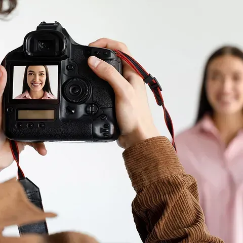 Una persona está tomando una fotografía de una mujer con una cámara.
