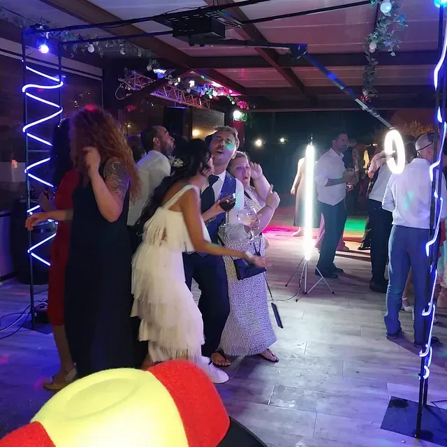 Un grupo de personas posa para una fotografía frente a un anillo de luz.