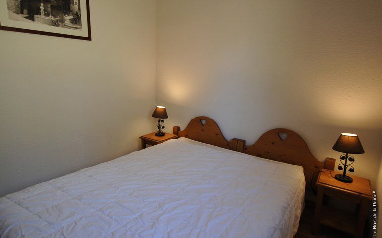 Lit double avec tête de lit en bois et deux tables de chevet