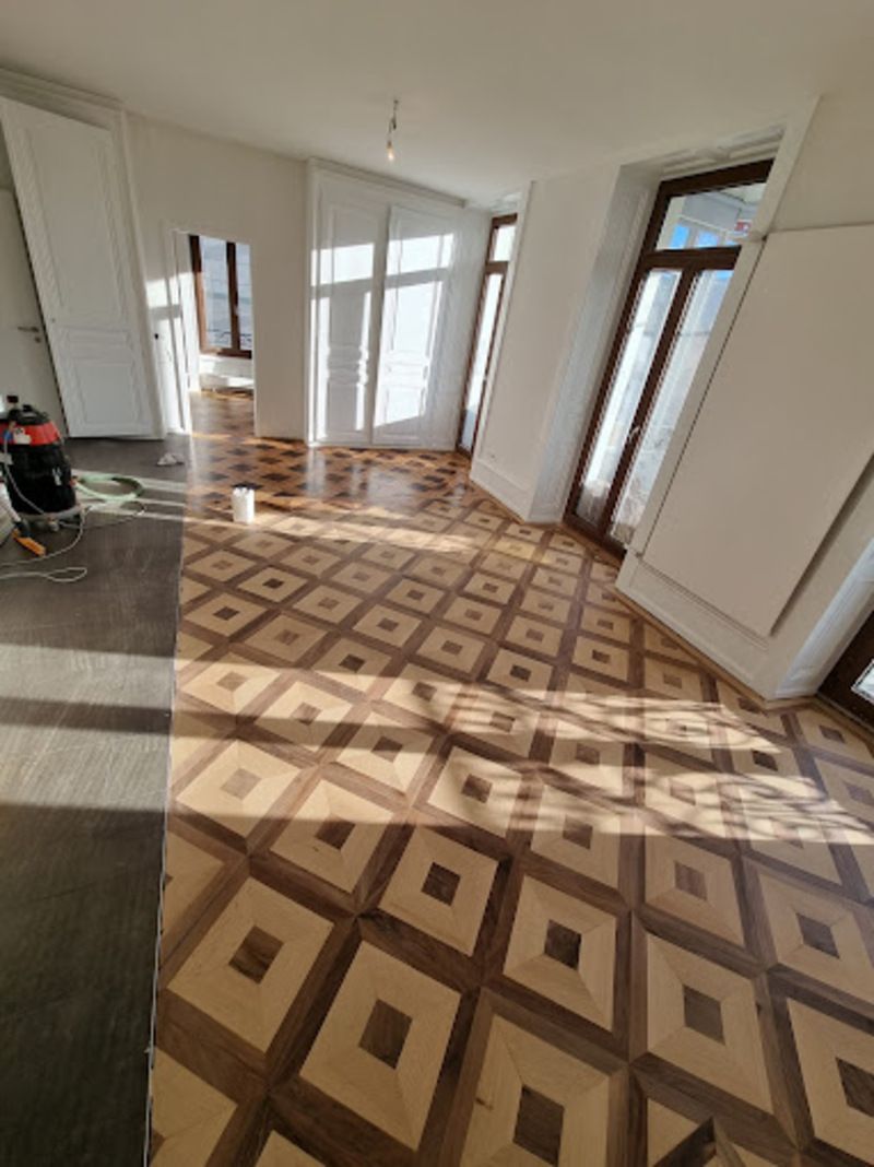 Une pièce avec du parquet et des murs blancs