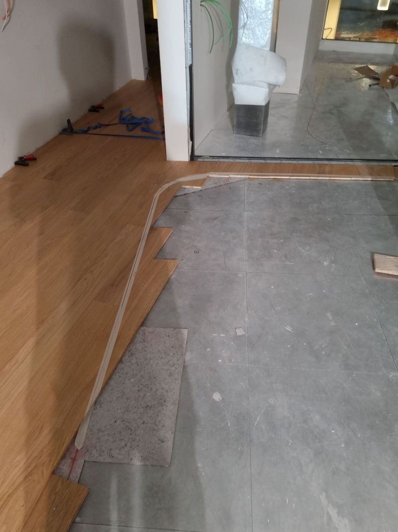 Un parquet est en cours de pose dans une pièce.