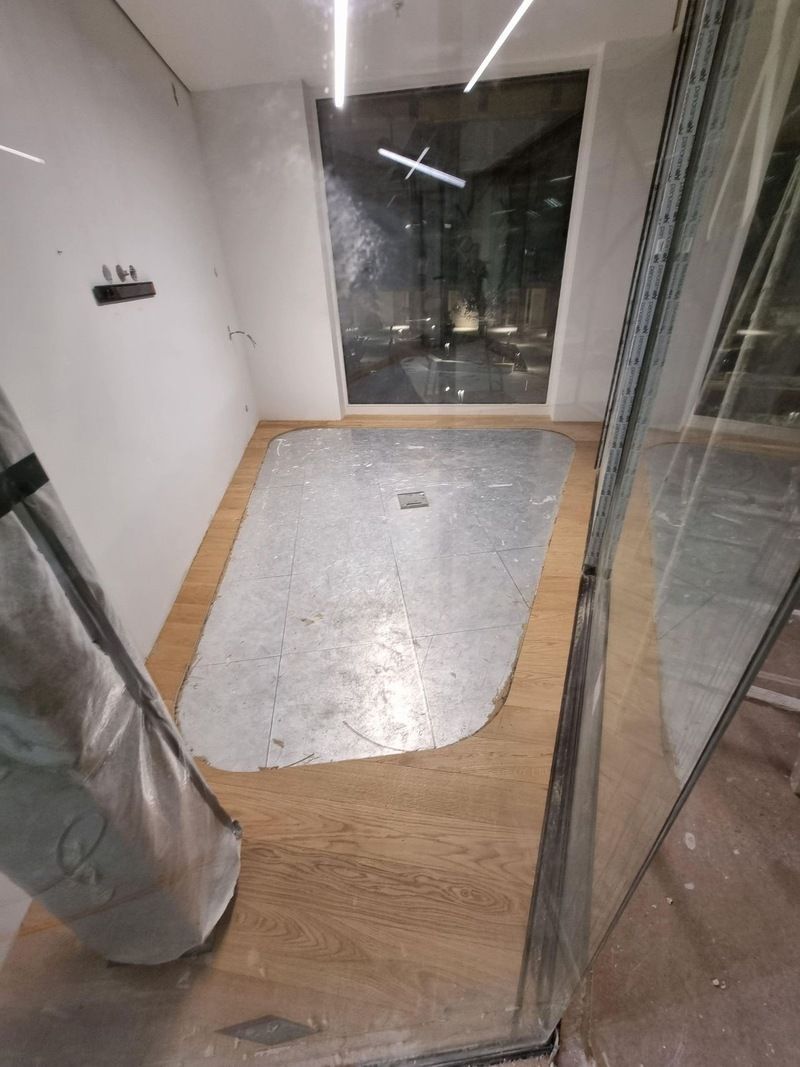 Une pièce avec du parquet et une grande fenêtre.