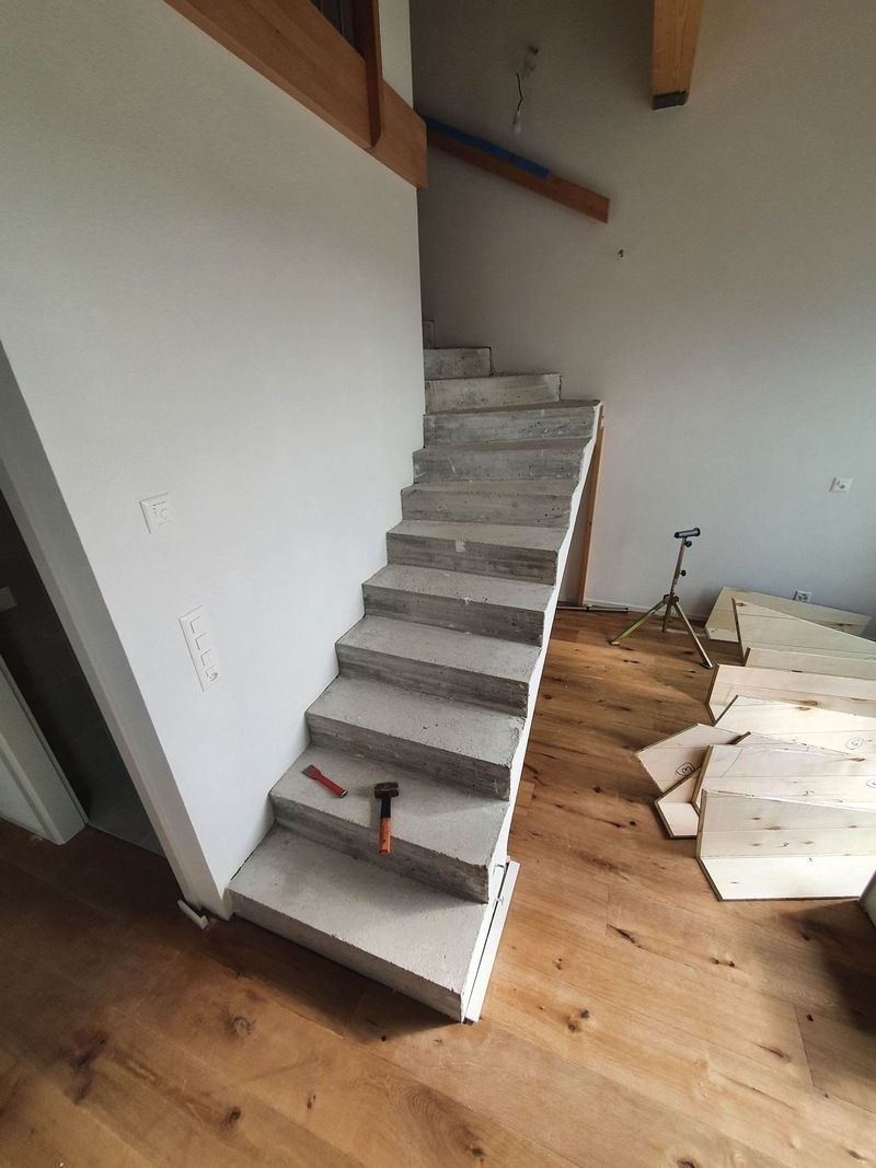 Un escalier est en cours de construction dans une pièce avec parquet.
