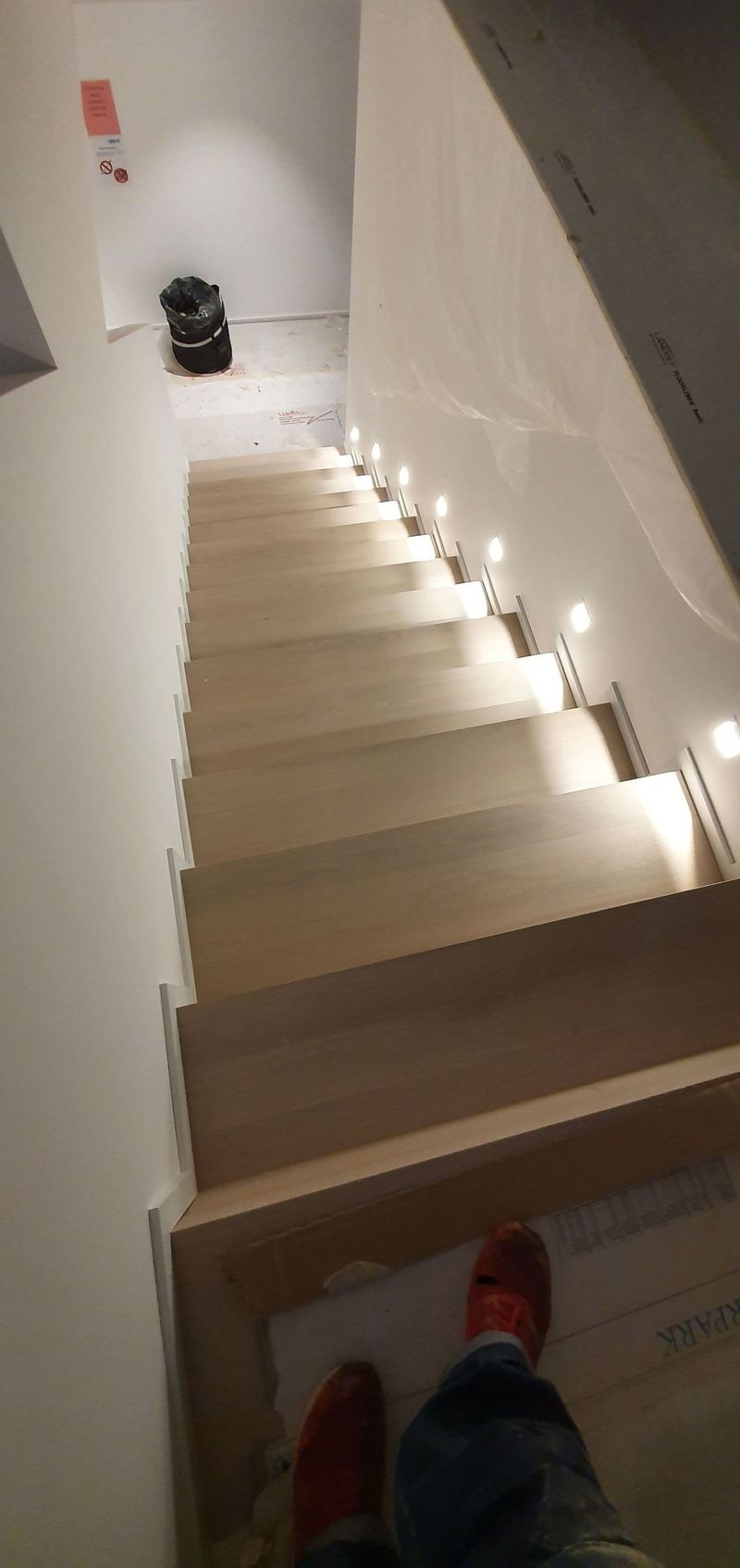 Une personne se tient debout sur un escalier avec des lumières allumées.