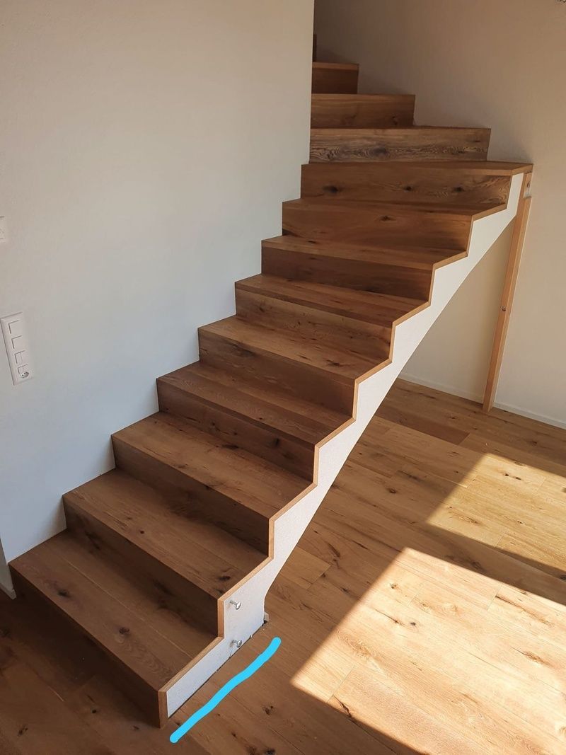Un escalier en bois avec une balustrade blanche dans une pièce.