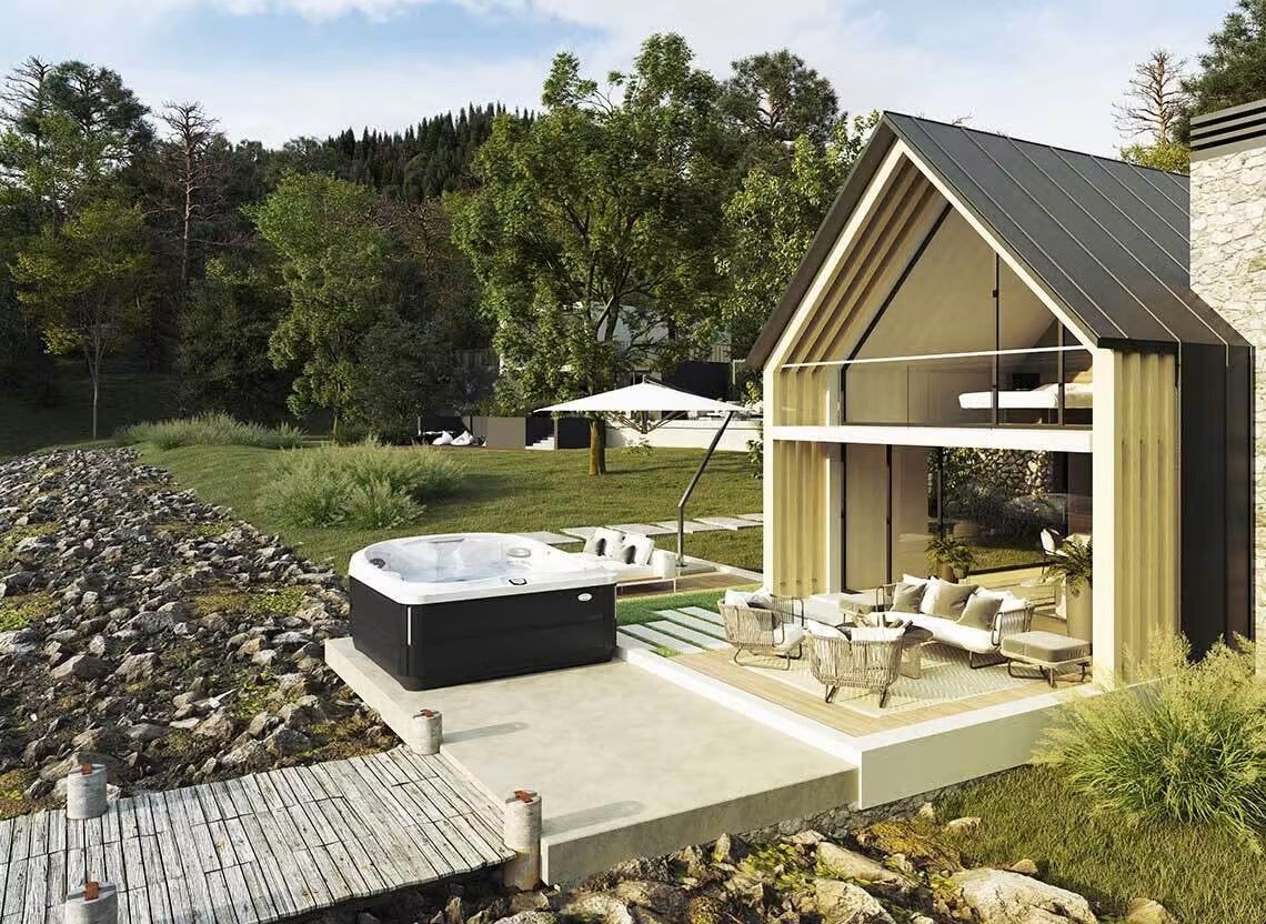 Chalet moderne avec jacuzzi au bord d'un lac, comprenant un coin salon extérieur et une pelouse.