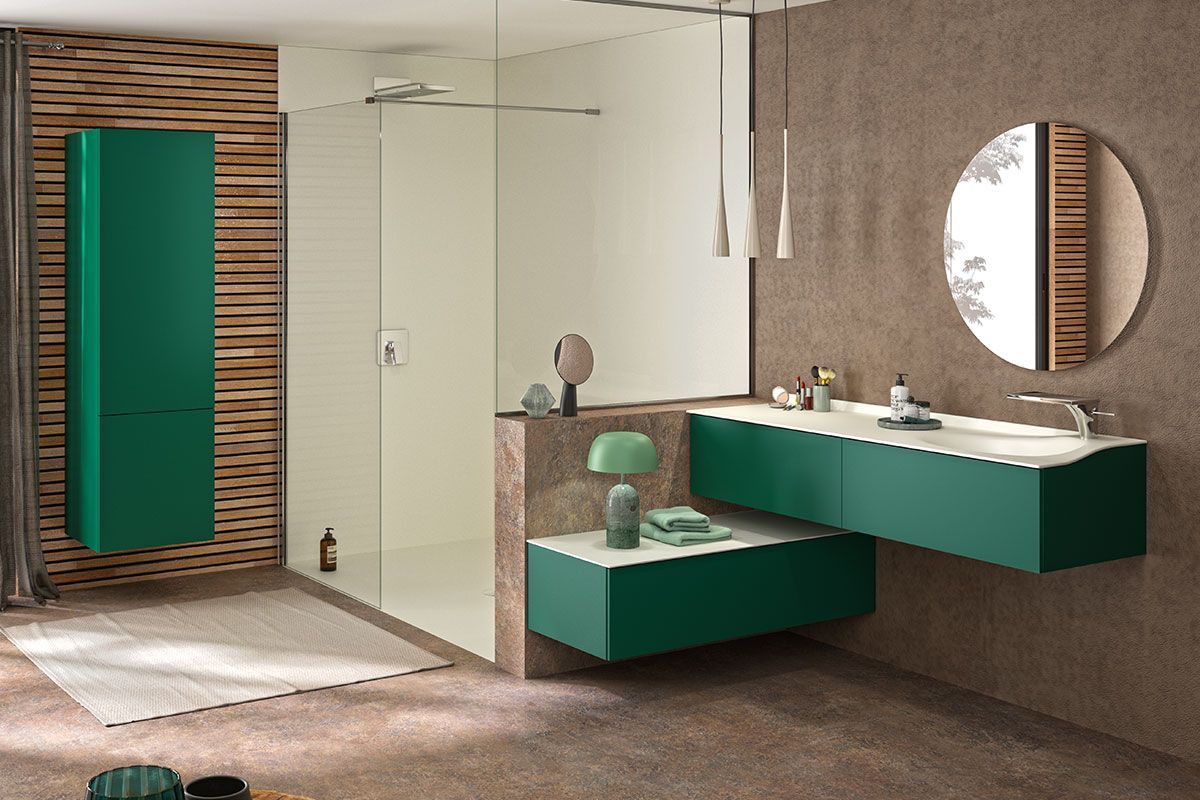 Salle de bains moderne avec meubles verts, miroir rond et mur d'accent en bois.