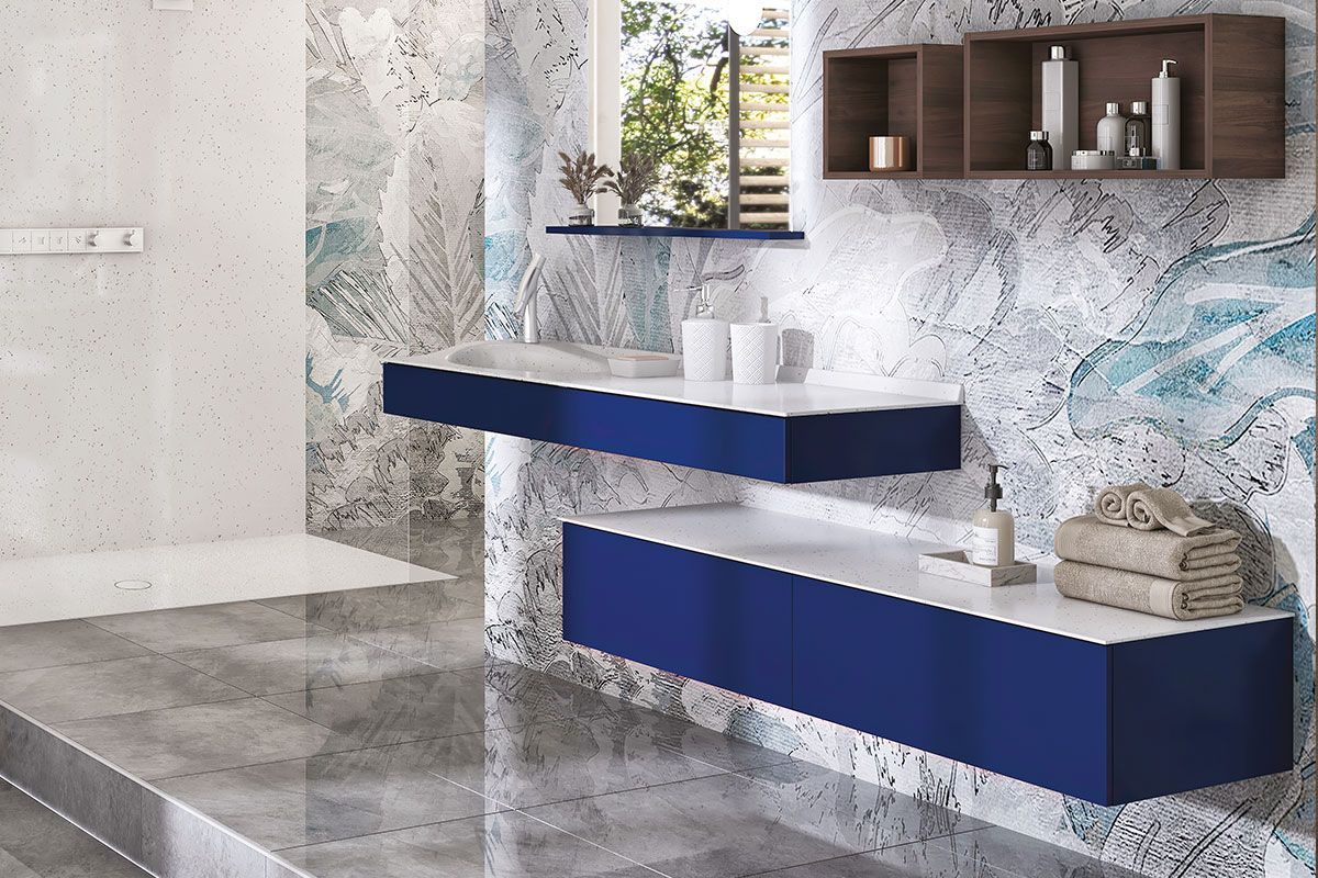 Salle de bains moderne avec meubles suspendus bleus, murs imitation marbre et douche.