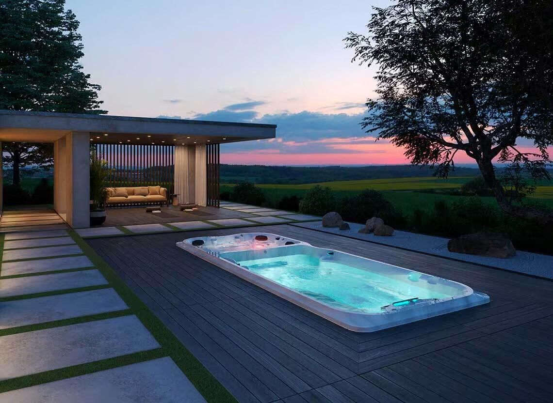 Spa extérieur sur une terrasse au crépuscule, à côté d'un coin salon couvert avec vue sur un champ.