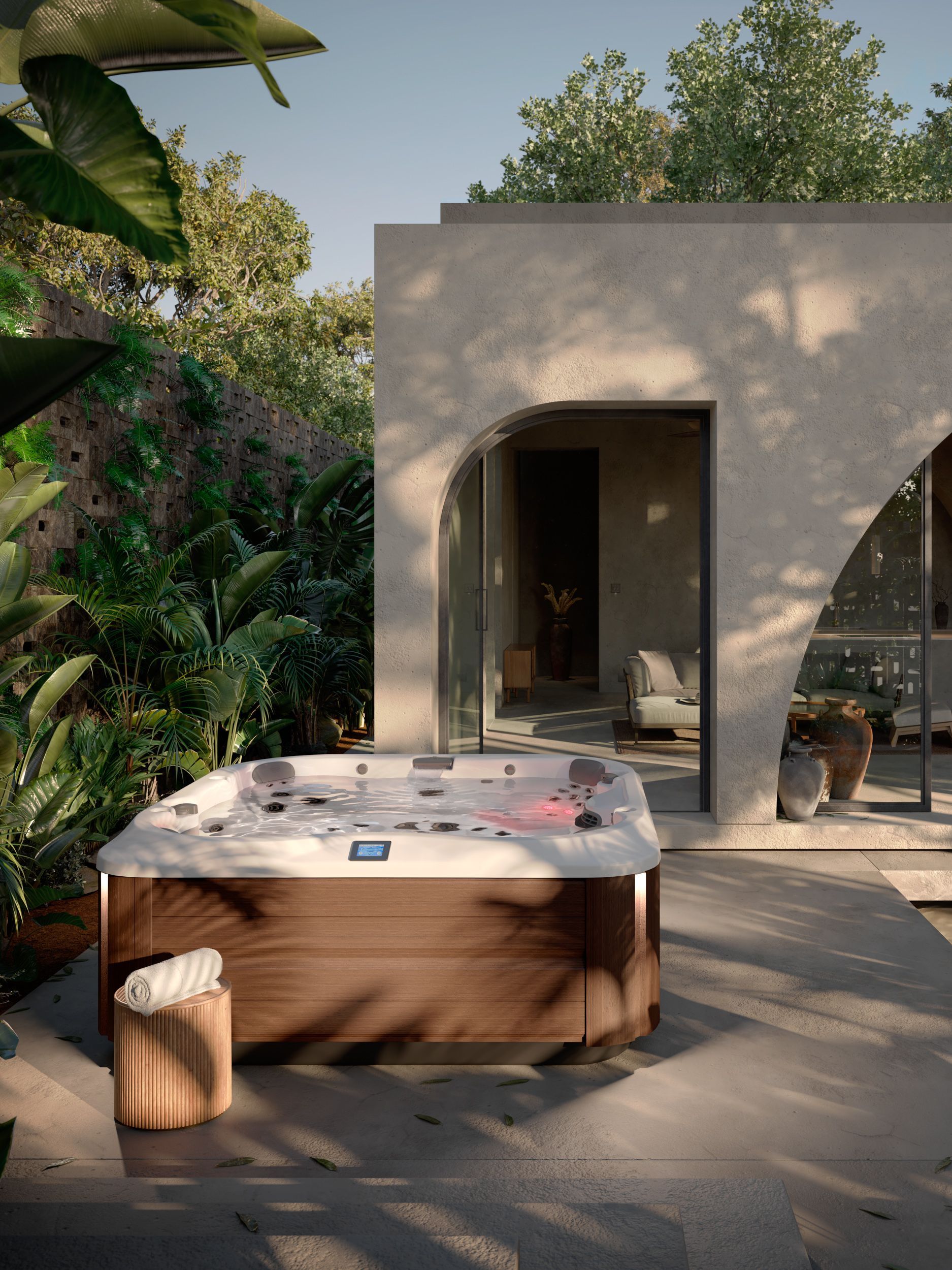 Bain à remous près d'un bâtiment moderne avec sièges extérieurs et végétation luxuriante.