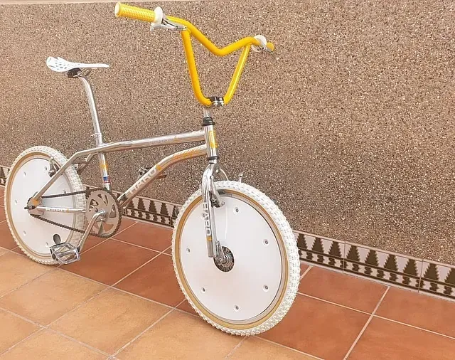 Una bicicleta está estacionada en un piso de baldosas frente a una pared.