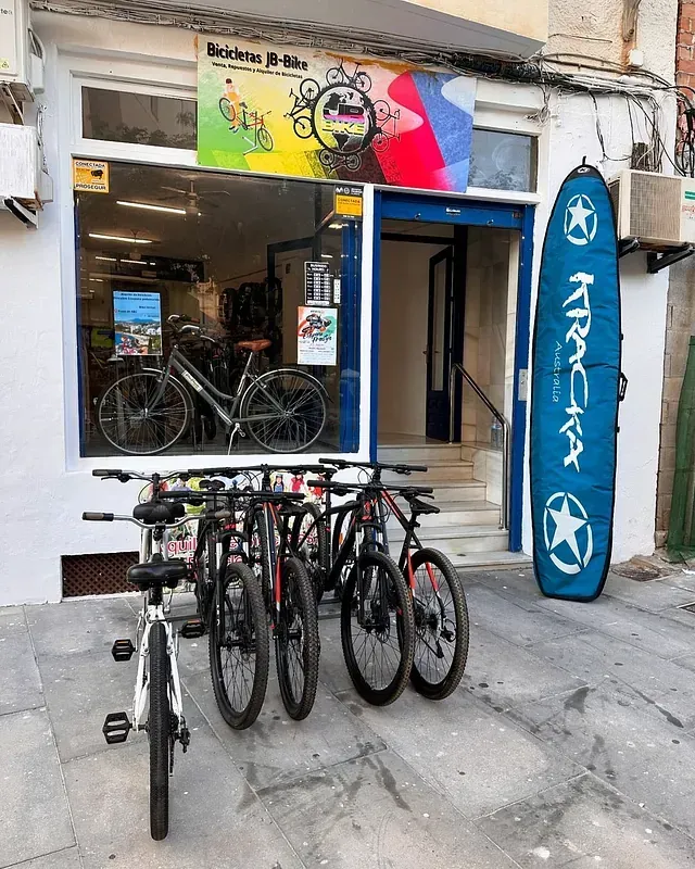 Un montón de bicicletas están estacionadas frente a una tienda.