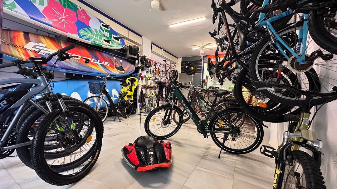 Una tienda llena de bicicletas y tablas de surf.
