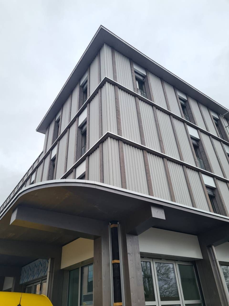 Zimmerrenovierung, blaue und graue Wände. Pappkartons, Leiter, Sofa und Pflanze. Sichtbare Deckenbalken.