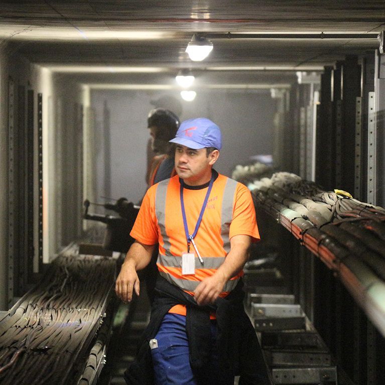 Professionnel dans un couloir avec des câbles de réseaux électriques.
