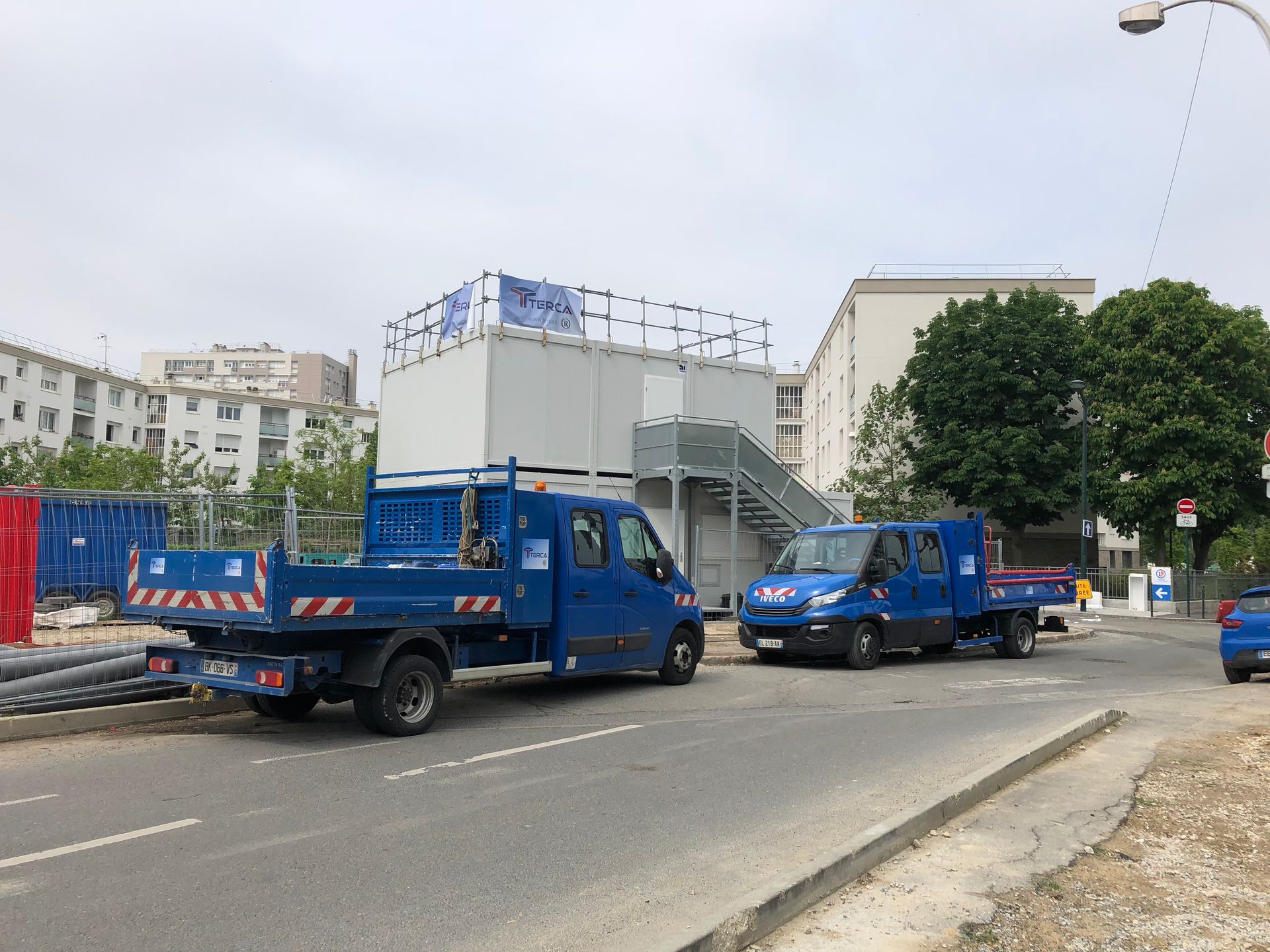 Nombreux véhicules bleus garés devant des bâtiments.