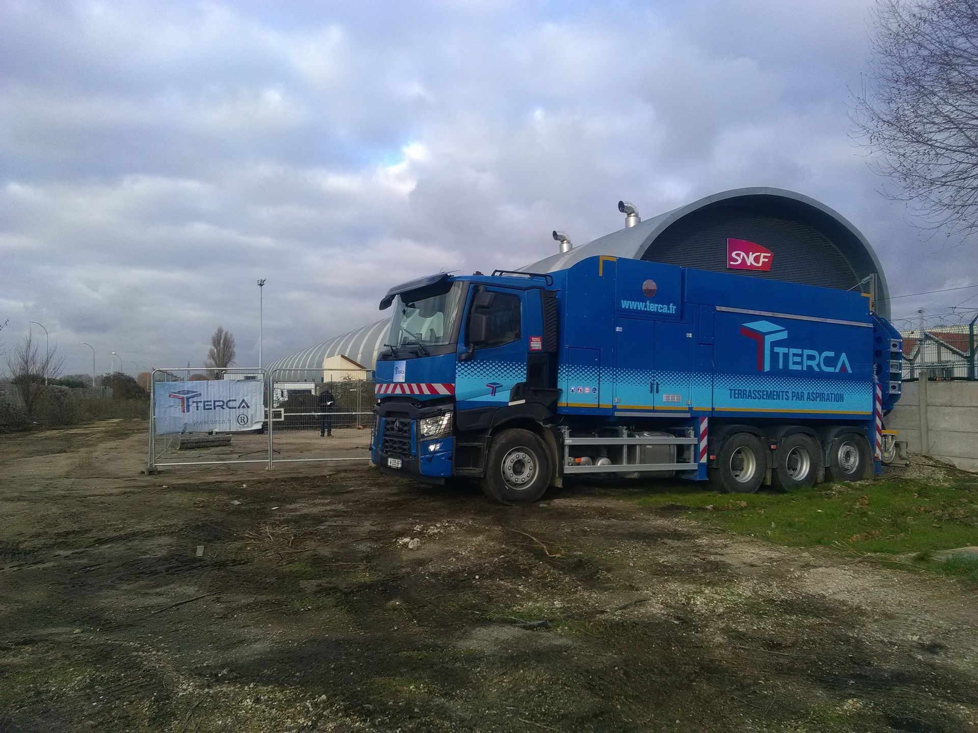 Camion bleu Terca près d'un entreprot SNCF.
