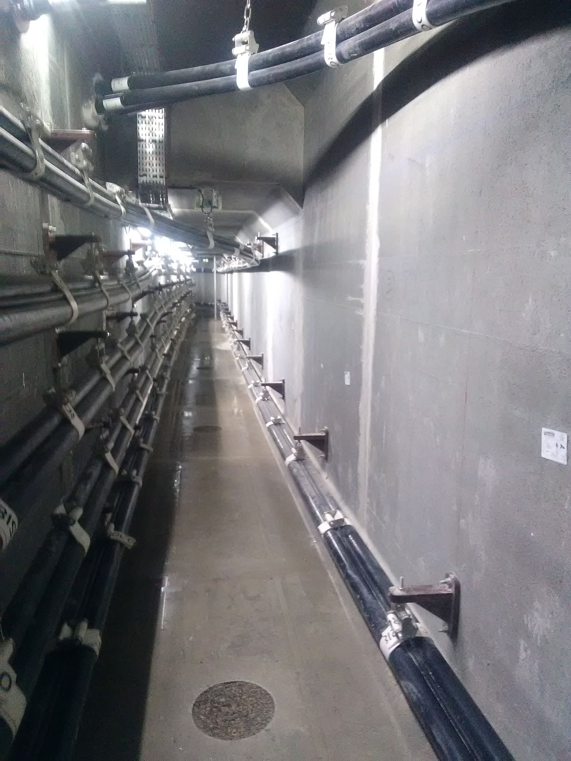 Long couloir avec des conduites sur les murs.