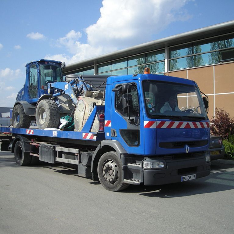 Camion transportant un engin de chantier.