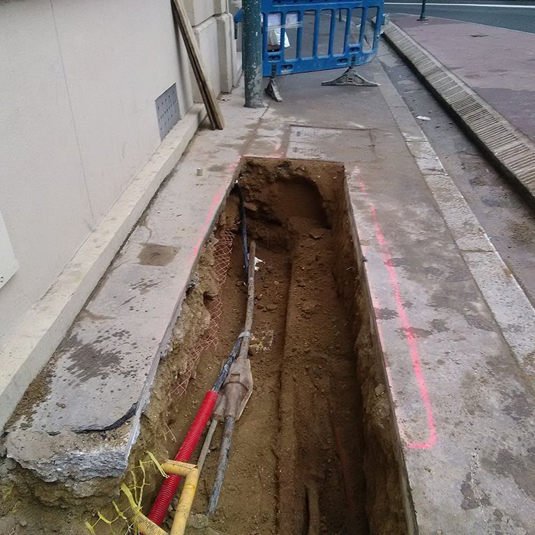 Chantier sur une conduite sous un trottoir.