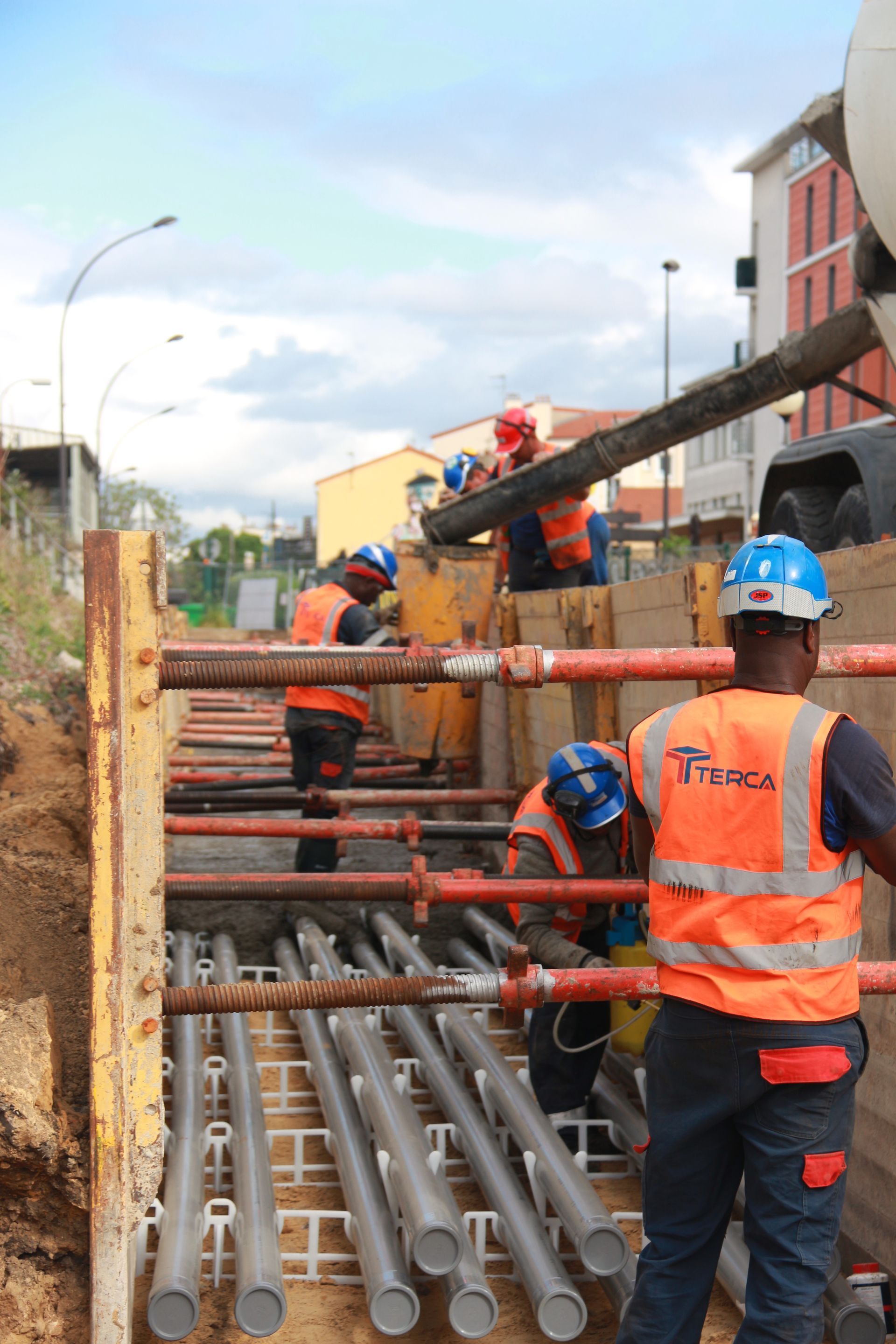 Groupe de professionnels dans une tranchée sécurisée pour des travaux.